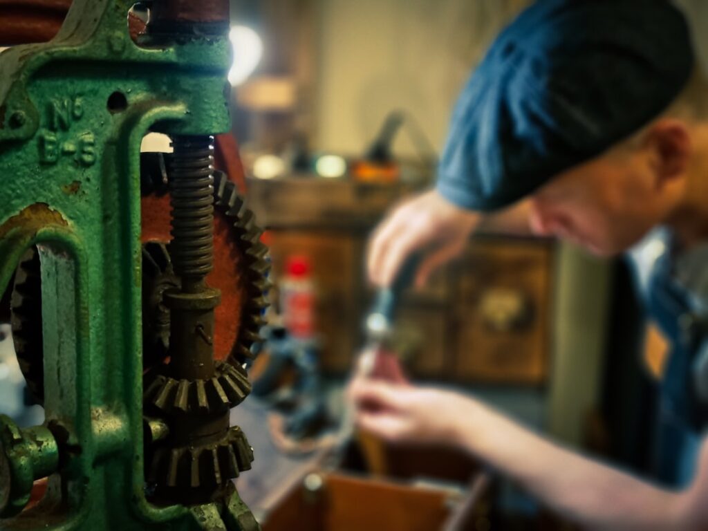 industrial gearbox repair specialist working on large gear reducer on factory floor