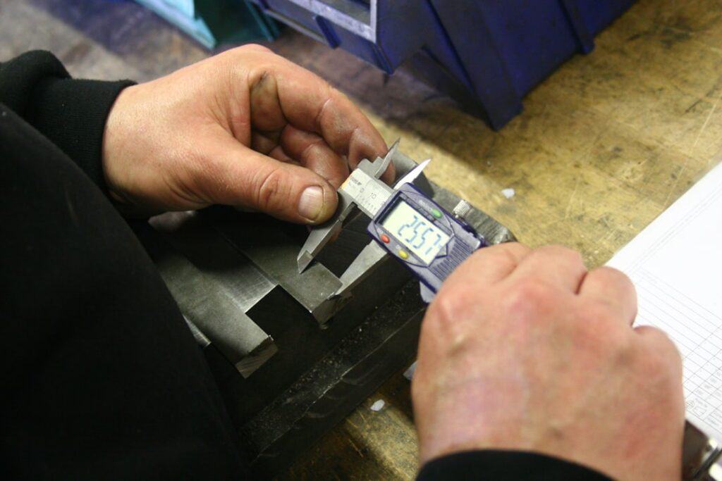 Engineer verifying nameplate catalog numbers and measuring shaft tolerances